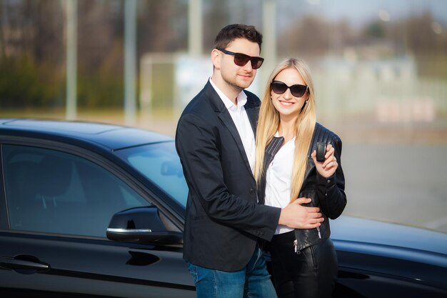 Gelukkig paar kopen nieuwe moderne zwarte auto.