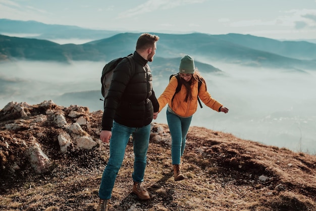 Gelukkig paar man en vrouw toerist op de top van de berg tijdens een wandeling in de zomer