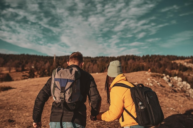 Gelukkig paar man en vrouw toerist op de top van de berg tijdens een wandeling in de zomer