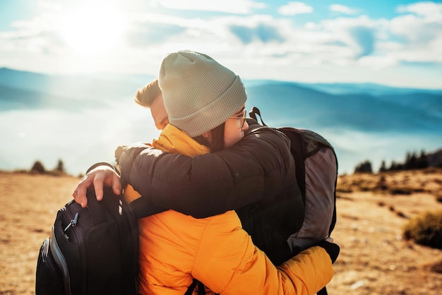 Foto gelukkig paar man en vrouw toerist op de top van de berg tijdens een wandeling in de zomer