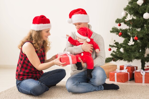 Gelukkig paar met baby die Kerstmis samen thuis vieren.