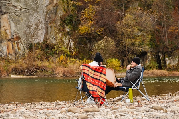 gelukkig paar met een picknick op het rivierstrand herfst seizoen