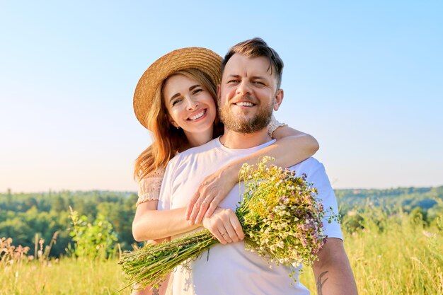 Gelukkig paar van middelbare leeftijd verliefd omarmen met een boeket wilde bloemen