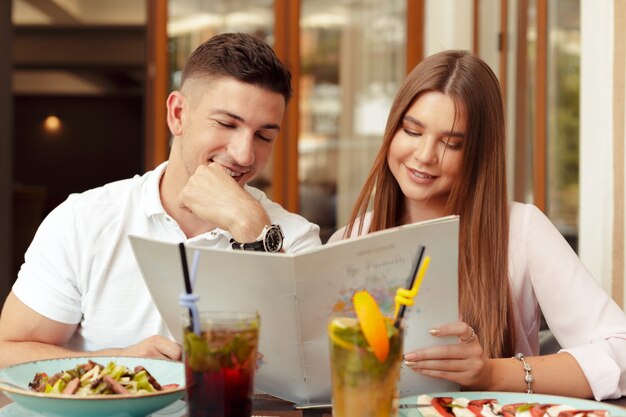 Gelukkig paar zitten in café en kijken naar menu