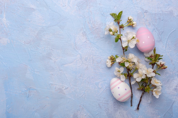 Gelukkig Paaskaart met beschilderde eieren en bloemen op kleurrijke tafel, vakantie achtergrond voor uw kaart. Eierenjacht, kopieer ruimte