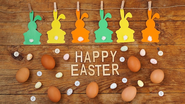 Gelukkig Pasen achtergrond. Garland van papier konijnen op een houten ondergrond. Konijntjesachtergrond met eieren. lente decor