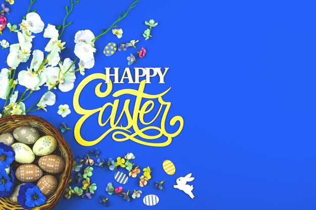 Gelukkig Pasen achtergrond met ei nesten en lentebloem, blauwe achtergrond en bovenaanzicht foto