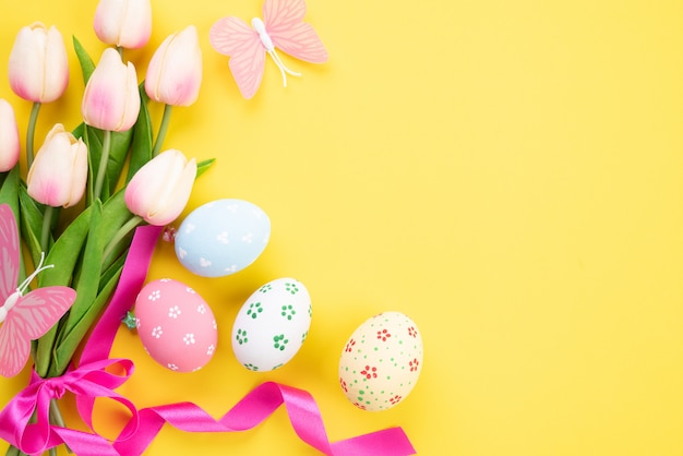 Gelukkig Pasen! Kleurrijk van paaseieren in nest met roze tulpenbloem