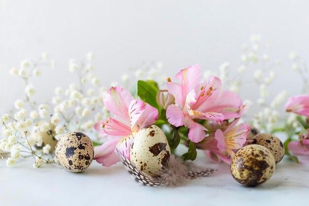 Gelukkig Pasen kwarteleitjes veren lente roze bloemen op marmeren achtergrond