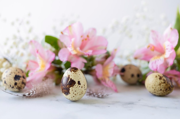 Gelukkig Pasen kwarteleitjes veren lente roze bloemen op marmeren achtergrondxA