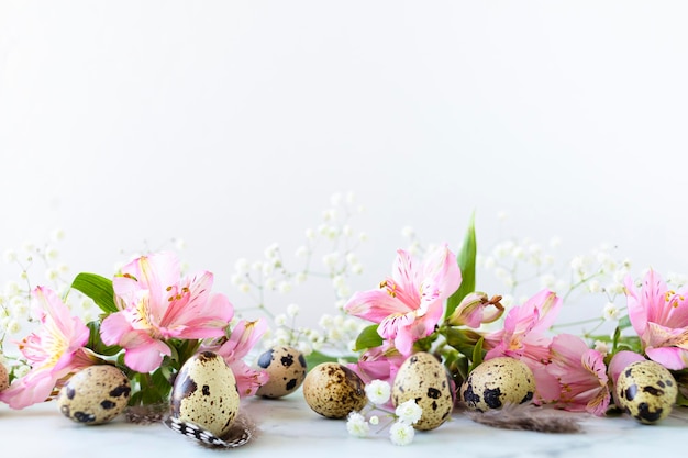 Gelukkig Pasen kwarteleitjes veren lente roze bloemen op witte achtergrond