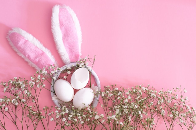 Gelukkig Pasen. Plat leggen van Pasen oren en gypsophila bloemen op een roze achtergrond. Pasen achtergrond. Pasen concept