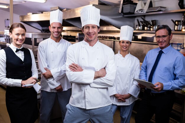 Gelukkig restaurantteam die zich in commerciële keuken verenigen