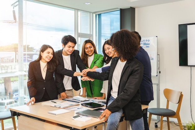 Gelukkig samenwerken succesvol team van zakenmensen gemengd ras teamwerk de handen ineen op kantoor werkplek