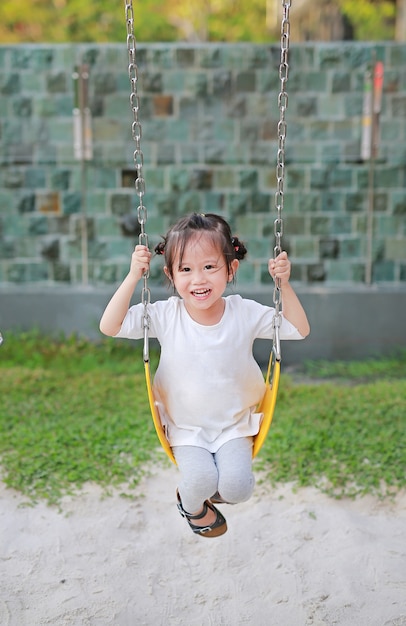 Gelukkig schattig klein meisje op schommel in het park