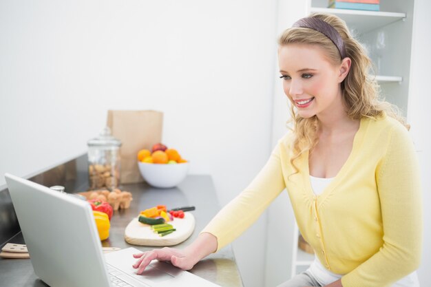 Gelukkig schattige blonde met behulp van laptop