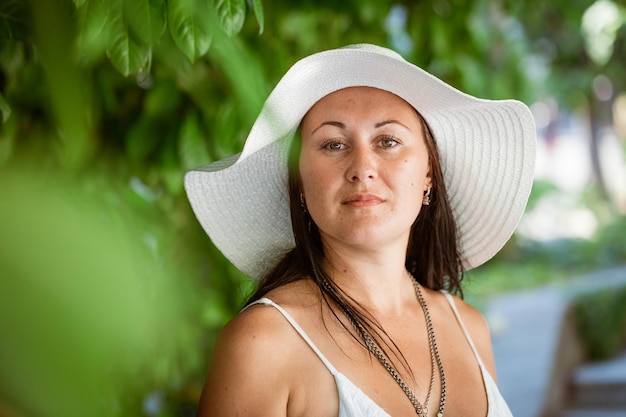 Gelukkig schattige brunette vrouw in park op zomerdag Vrolijke mooie vrouw