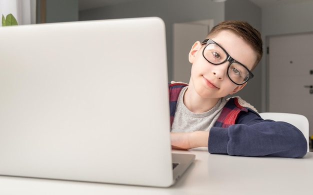 Gelukkig schattige tienerjongen in draadloze koptelefoon kijken naar laptopscherm luisteren educatieve online lezing