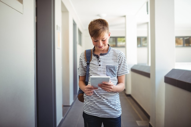 Gelukkig schooljongen met behulp van digitale tablet in gang