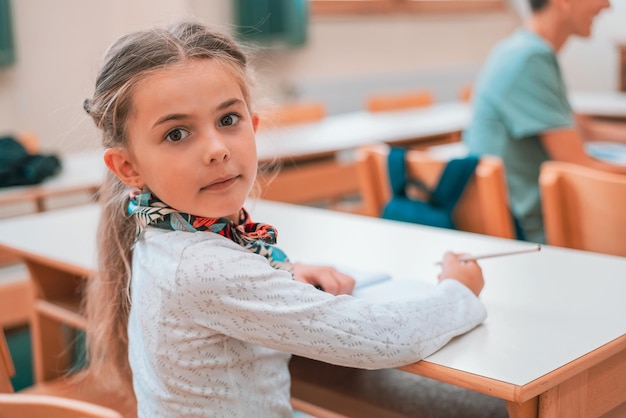 Gelukkig schoolkindmeisje tijdens de les in de klas.