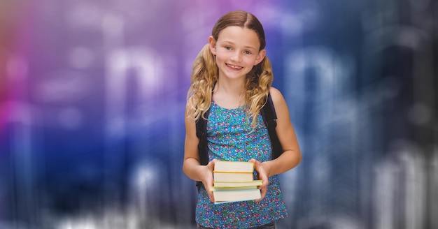 Gelukkig schoolmeisje dat boeken houdt over onscherpe achtergrond