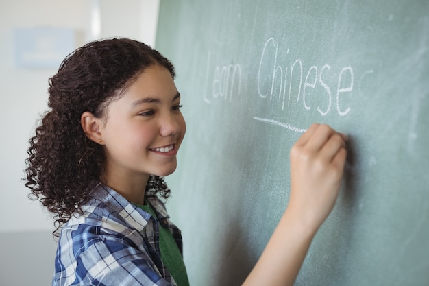 Gelukkig schoolmeisje dat zich voordoet als een leraar in de klas