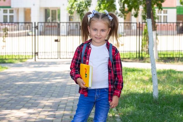 Gelukkig schoolmeisje met een leerboek in haar handen.