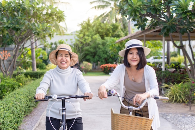 Gelukkig senior aziatische vrouwen fietsen met dochter in openbaar park,