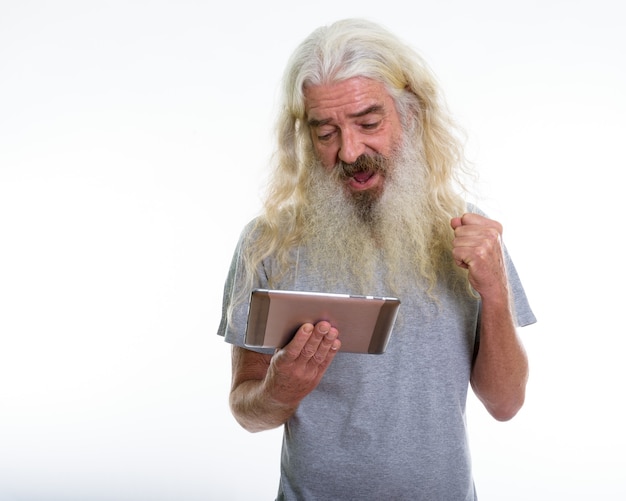 gelukkig senior bebaarde man glimlachend en op zoek naar een tablet