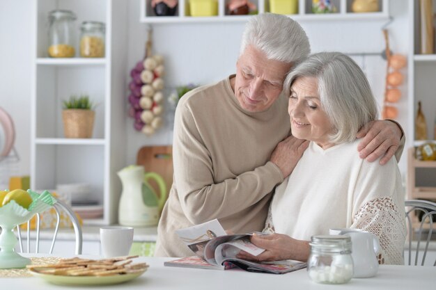 Gelukkig Senior koppel met tijdschrift thuis