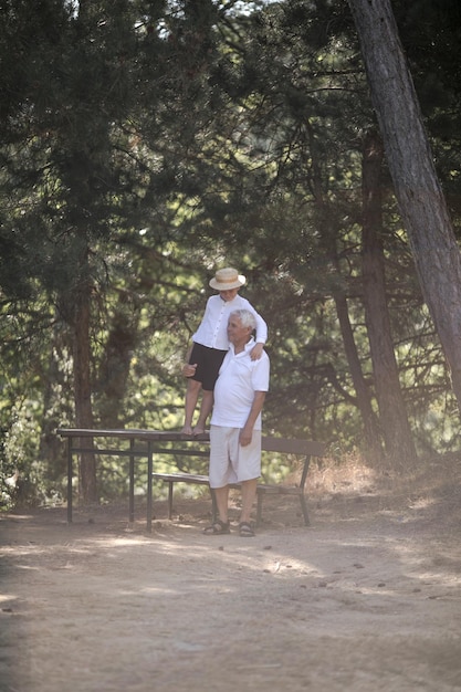 Gelukkig senior man grootvader met schattige kleine jongen kleinzoon spelen in het bos