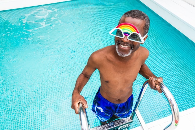 Gelukkig senior man met feest in het zwembad