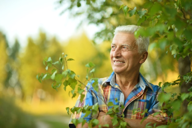 Gelukkig senior man op een wandeling in het park in de zomer