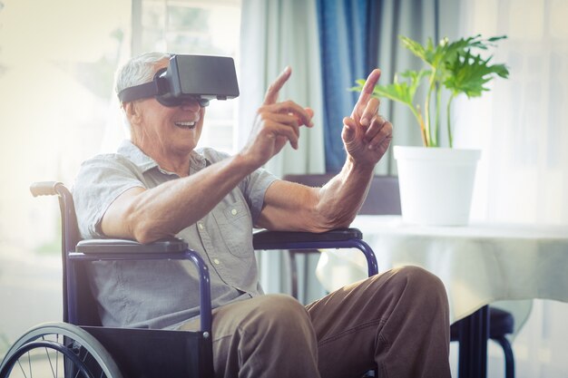 Gelukkig senior man op rolstoel met behulp van VR-headset