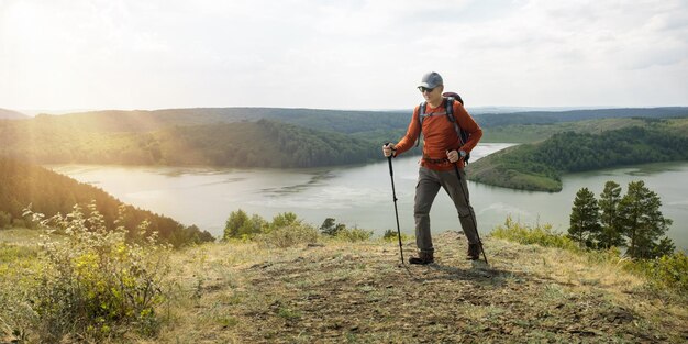 Gelukkig senior man wandelen met trekkingstokken en rugzak in de bergen Banner met kopieerruimte