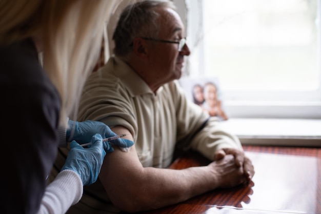 Gelukkig senior man wordt gevaccineerd.