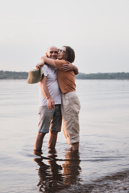 Gelukkig senior paar aziatische vrouw knuffelen echtgenoot in kust op zomervakantie Full body shot