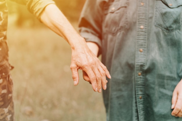 Gelukkig senior paar hand in hand van man en vrouw houden elkaar romantiek en liefde en steun in oudere familie anonieme man en vrouw reizen samen in de natuur, het leven op het platteland