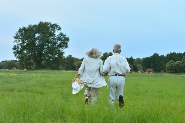 Gelukkig senior paar rennen op zomerveld