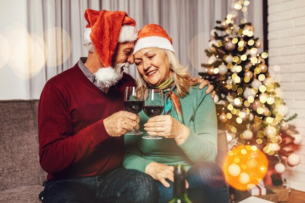 Gelukkig senior paar wijn drinken en Nieuwjaar vieren bij hen thuis.