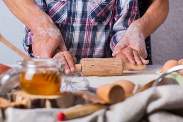 Gelukkig senior volwassen vrouw, grootmoeder en jonge jongen, kleinzoon koken, deeg kneden, taart bakken, cake, koekjes. Familie tijd in de gezellige keuken. Herfstactiviteit thuis.