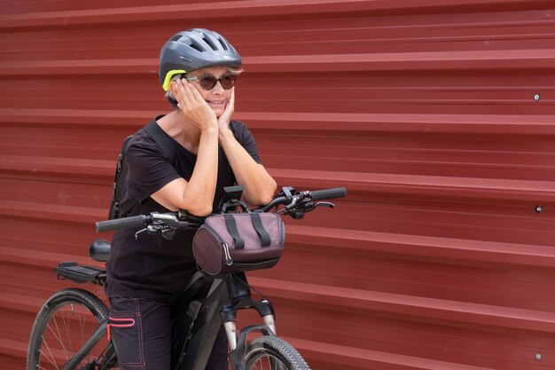 Gelukkig senior vrouw fietser in buitenexcursie in stedelijke stad genieten van een gezonde levensstijl