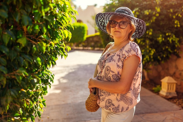 Gelukkig senior vrouw lopen op het grondgebied van het hotel Zomervakantie Stijlvolle modieuze look