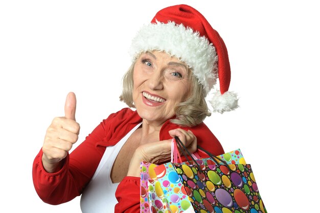 Gelukkig senior vrouw met boodschappentassen in Santa Claus cap