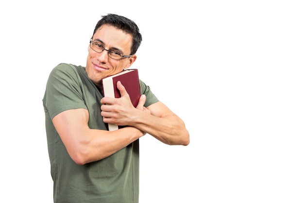 Gelukkig slimme man in groen t-shirt en bril omarmen interessant boek en kijken naar camera tegen witte achtergrond