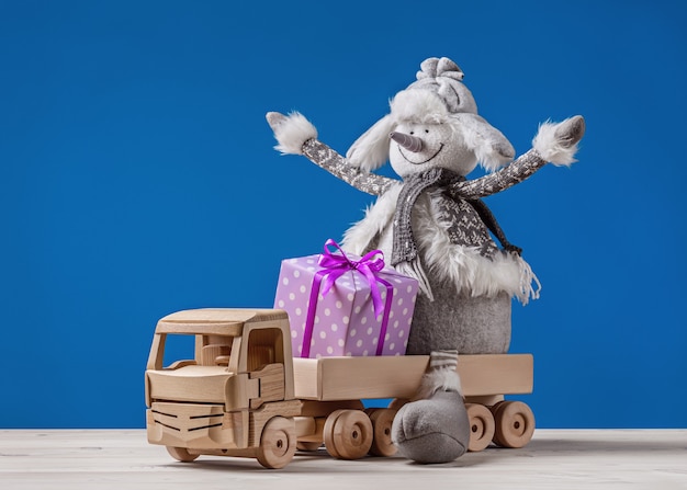 Gelukkig sneeuwpop met kerstcadeaus in speelgoed vrachtwagen.