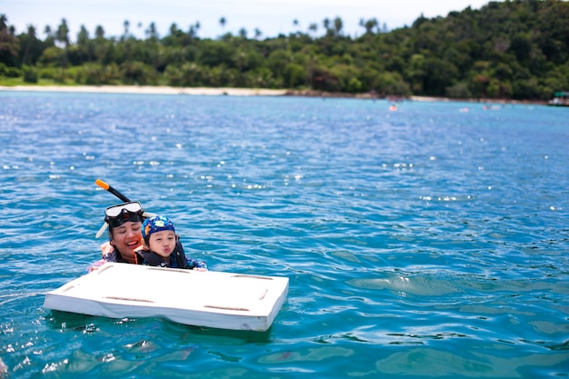 Gelukkig snorkel moeder en zoon plezier in oceaanwater snorkelen op Caribische vakantie in Thailand
