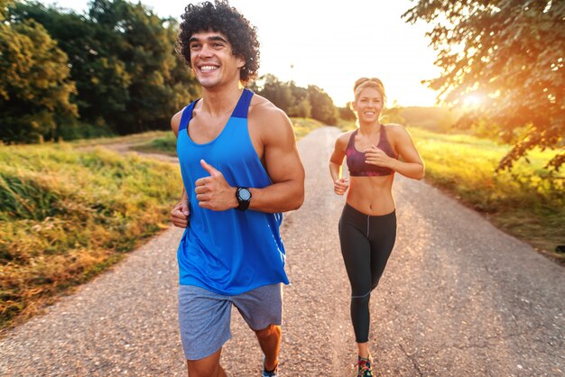 Foto gelukkig sportief paar dat voor marathon in de aard voorbereidingen treft. zonnige zomerdag.