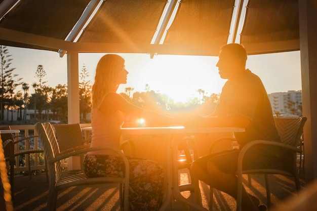 Gelukkig stel aan een tafel aan zee bij zonsondergang natuur