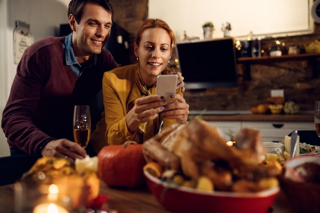 Gelukkig stel dat een foto maakt van hun Thanksgiving-kalkoen aan de eettafel